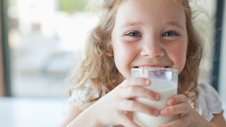 Picture of little girl smiling and drinking milk