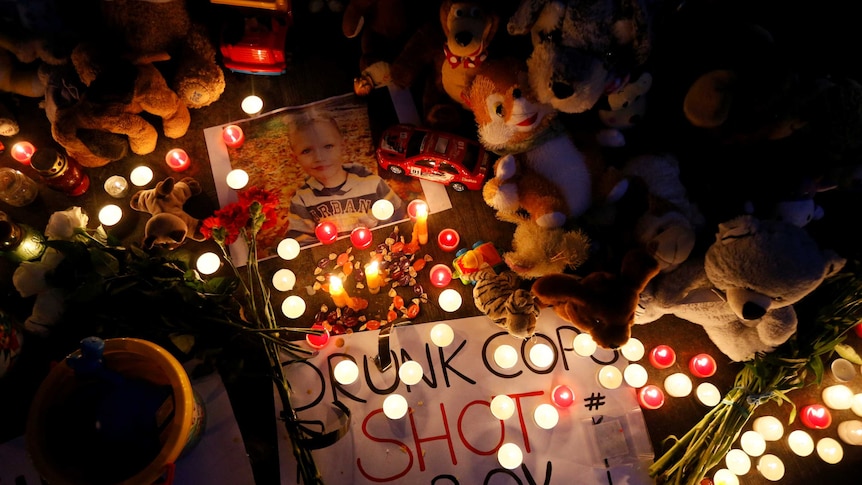 A vigil with toys and candles outside the headquarters of the Interior Ministry, with the photo of Kyrylo Tiavov.
