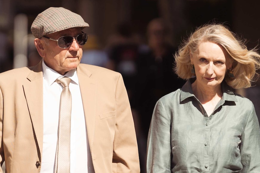 Don Spiers wearing a tan jacket and flat cap and Carol Spiers wearing a khaki dress outside court.