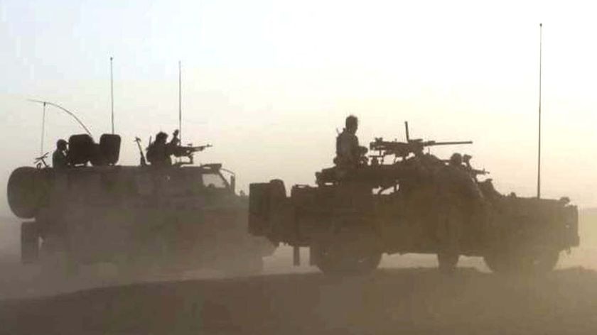 Dust swirls around soldiers with the Australian Special Operations Task Group