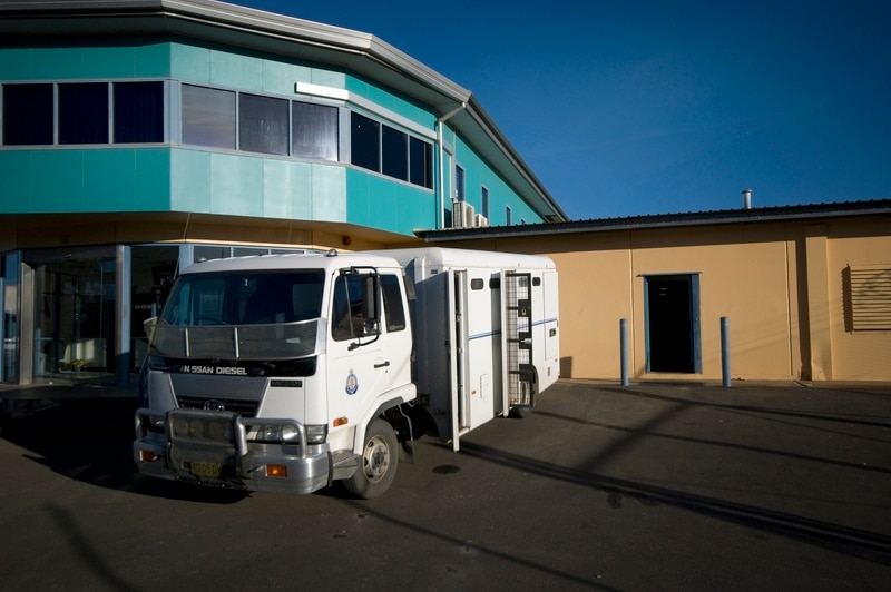 A white truck used for transporting prisoners sits outside the walls of Junee Correctional Centre.