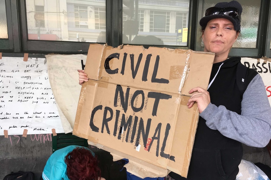 A woman protests at a makeshift homeless camp outside Flinders Street Station