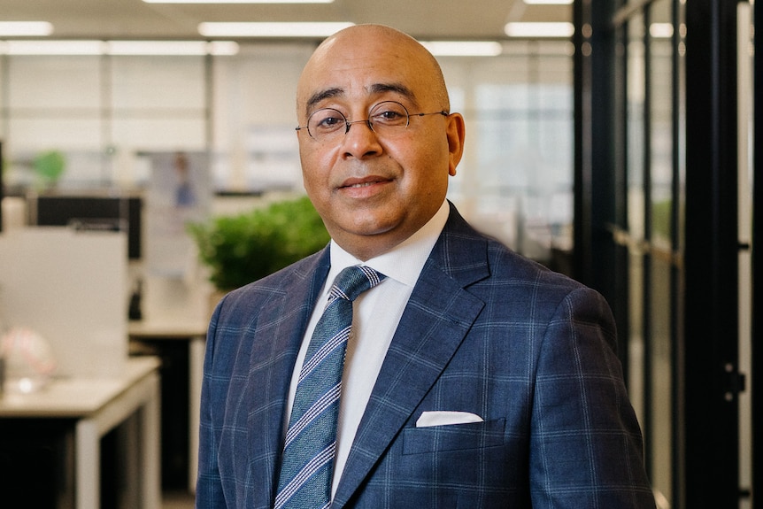 A lawyer in a blue suit looking at the camera