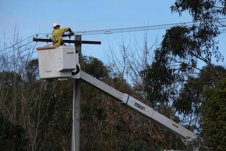 A worker in high-ris fixes a power line.