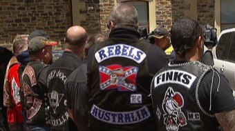 Bikies from various gangs show their colours with backs to the camera.