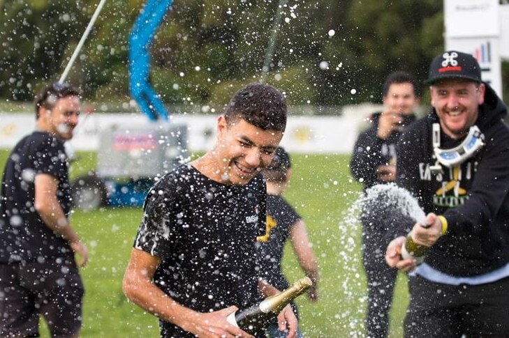 Thomas Bitmatta is sprayed with a bottle of champagne after wining the Australian Drone Nationals in Brisbane.