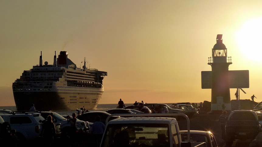 The Queen Mary 2 sails into the sunset as it leaves Fremantle.