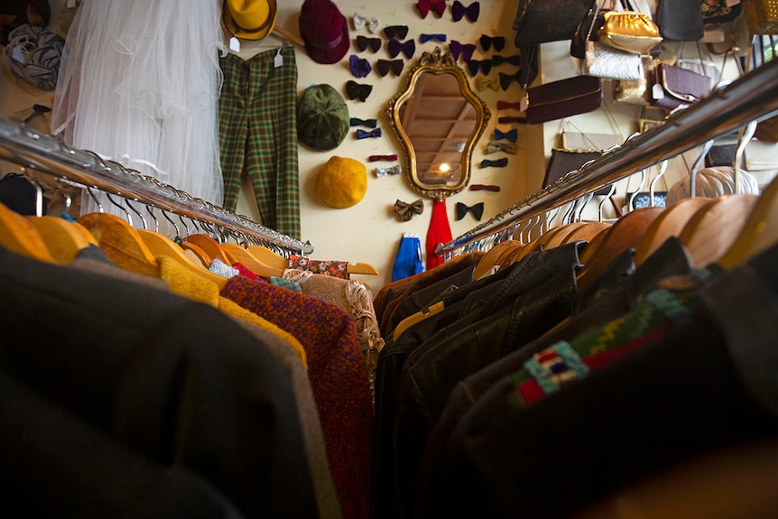 Vintage clothes, hats, bags and bow ties hang from the racks and walls.