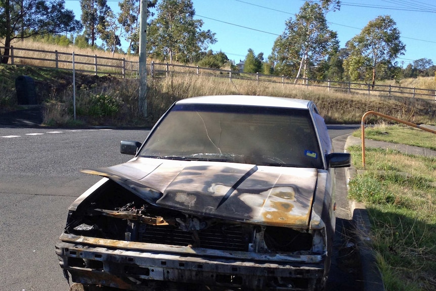 A burnt out car on a Tasmanian street.