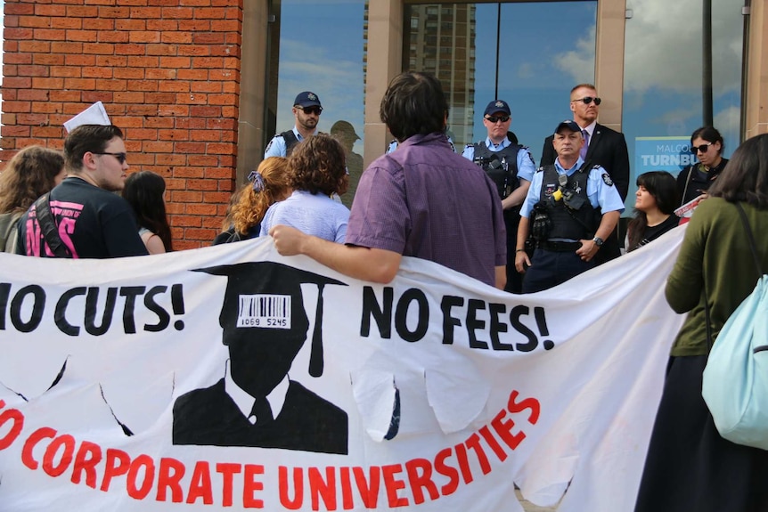 Protestors carry banner saying: No cuts! No fees! No corporate universities.