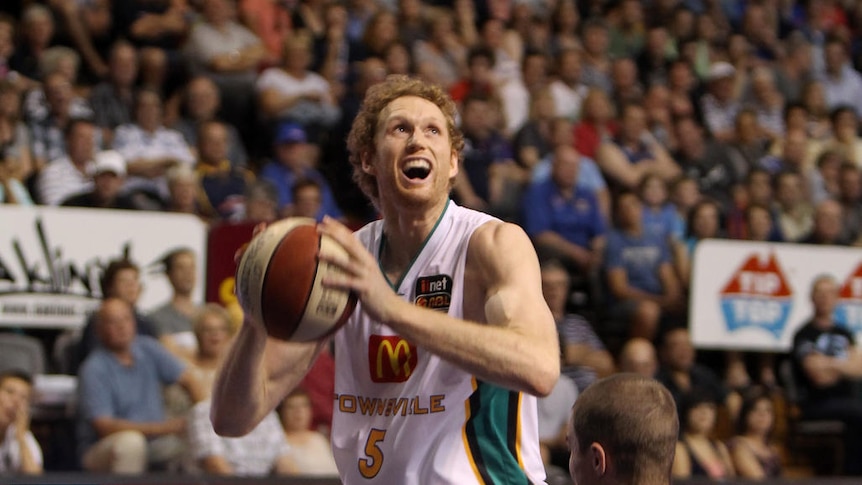 Making the big plays ... Luke Schenscher puts Jeff Dowdell on the floor before scoring in Adelaide.