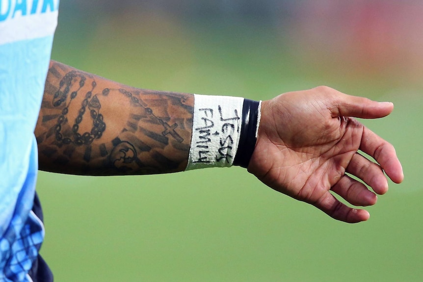 Israel Folau's arm with Jesus + family written on white wrist tape