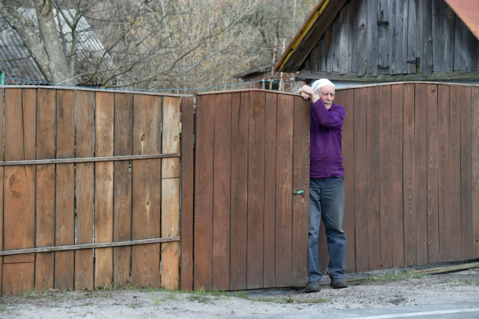 Yevgeny Markevich leans against a wooden fence at his home.
