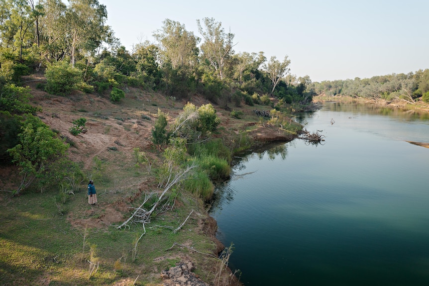 Woman standing next to a river.