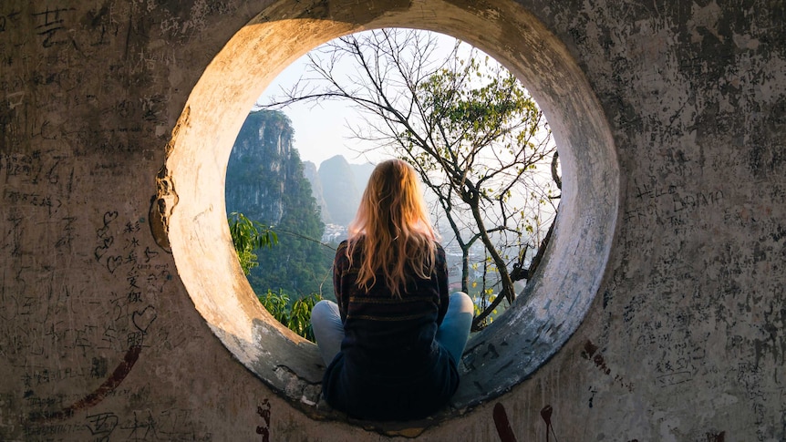 woman sitting looking out at mountains