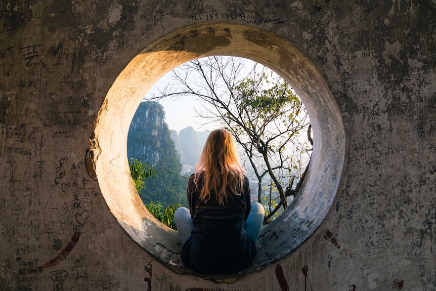 woman sitting looking out at mountains