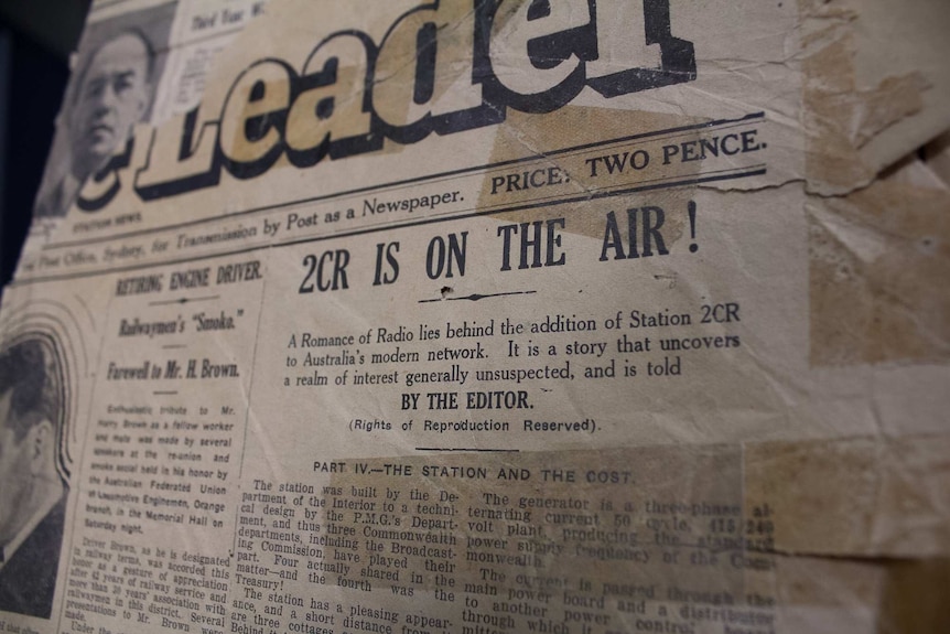 A faded yellowed newspaper article with the headline 2CR is on the Air
