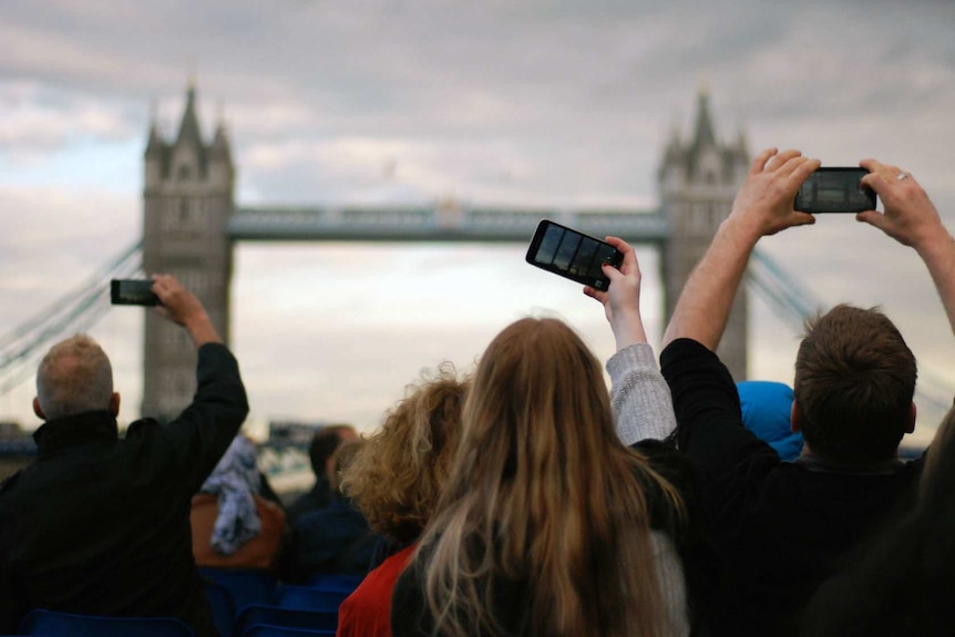 Gru di persone che scattano foto del London Bridge.