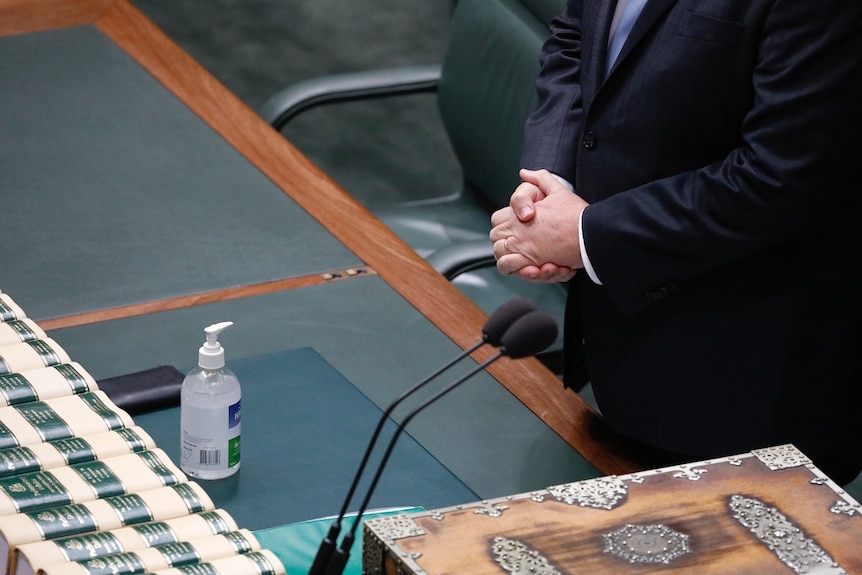 Hand sanitiser next to the despatch box in the House of Representatives, with Scott Morrison's hands in the background.