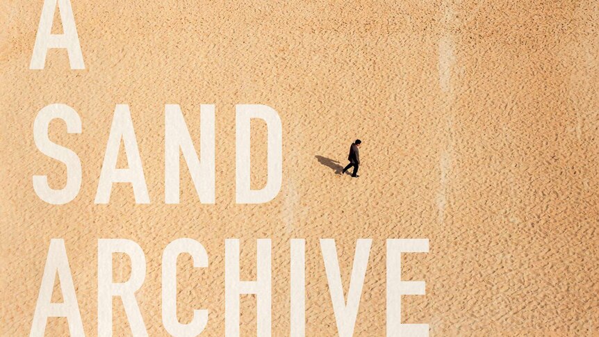 The book cover shows a birds eye view of a man alone on the sand.