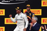 Mercedes driver Lewis Hamilton of Britain, center, jubilates on the podium after winning the Belgian Formula One Grand Prix.
