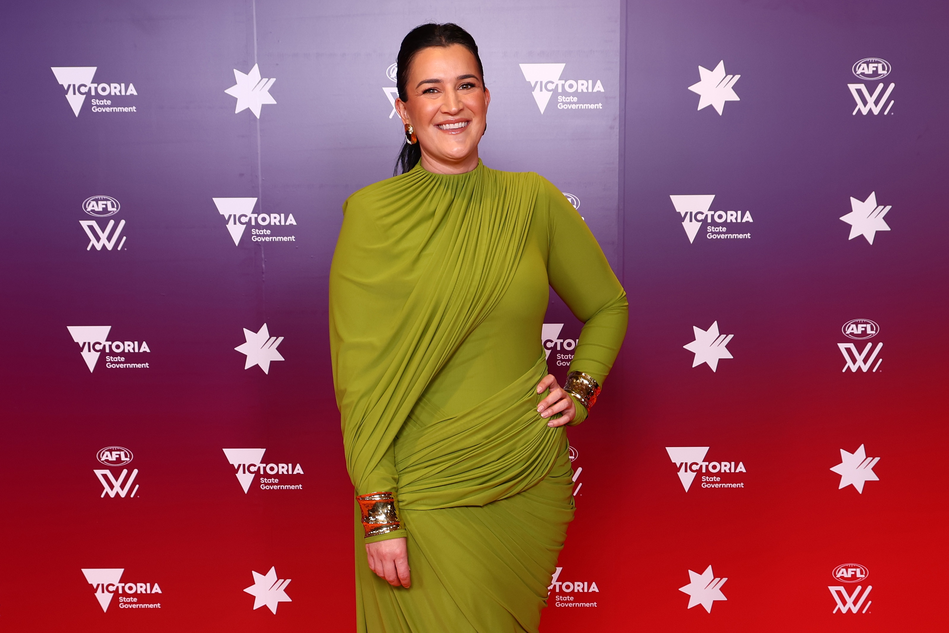 Uma mulher, Laura Kane, posa para uma fotografia com um vestido formal verde-limão.