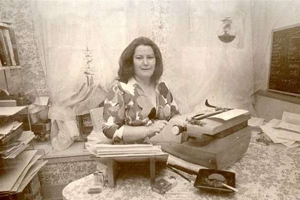 Colleen McCullough sitting at a typewriter