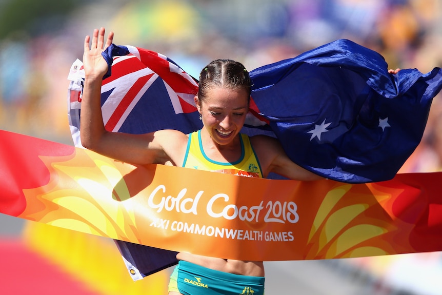 Jemima Montag crosses the line as she celebrates her gold medal in the Women's 20km Race Walk Final at Gold Coast, 2018.