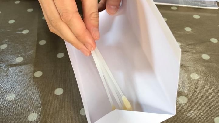 Swabs being placed into an envelope
