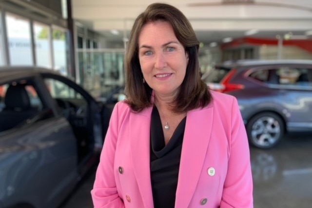 A woman smiling in a car dealership