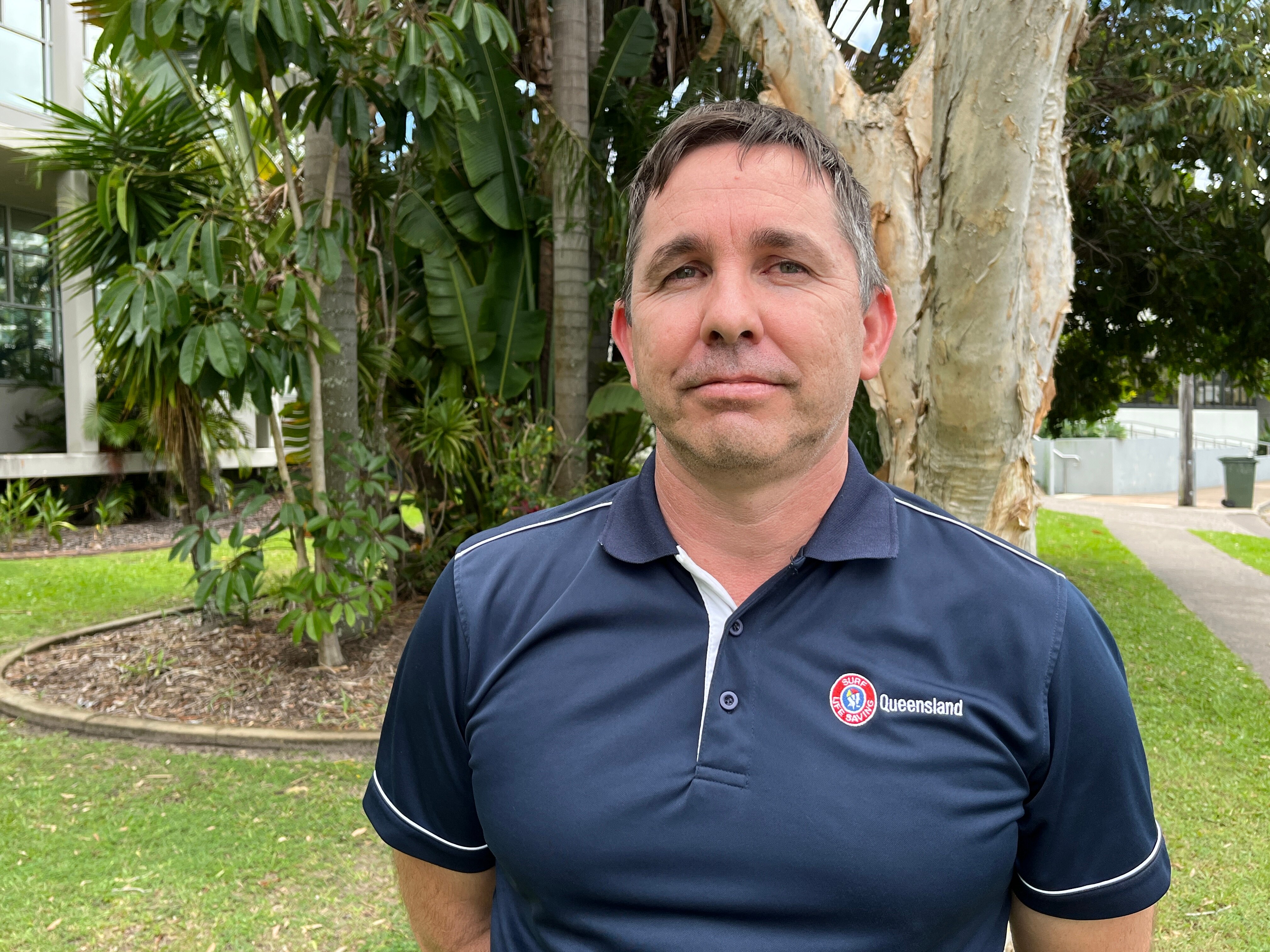 Man standing in front of tree and garden