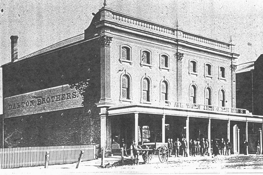 Grainy black and white photo of a two story 1800s building with Dalton Brothers across the top of the awning