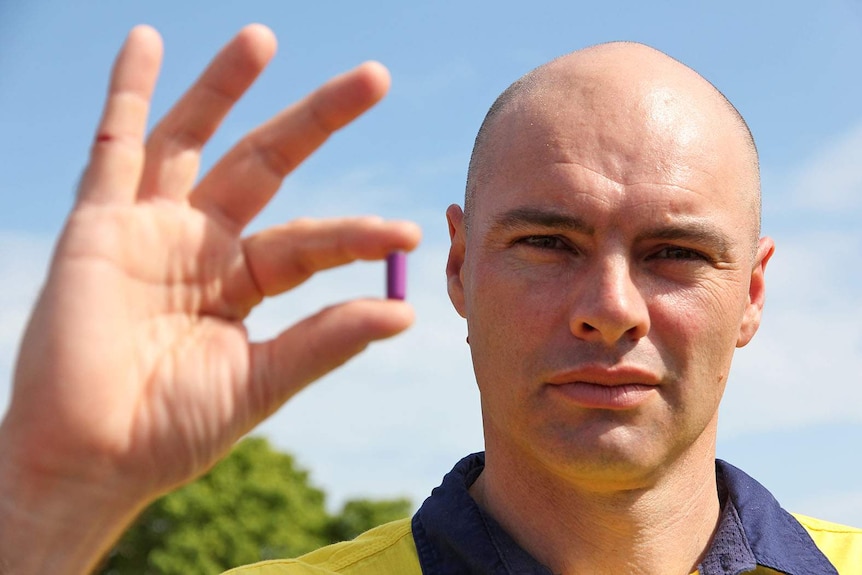 Heat stress consultant Matt Brearley stands with an ingestible pill that tracks core body temperature.