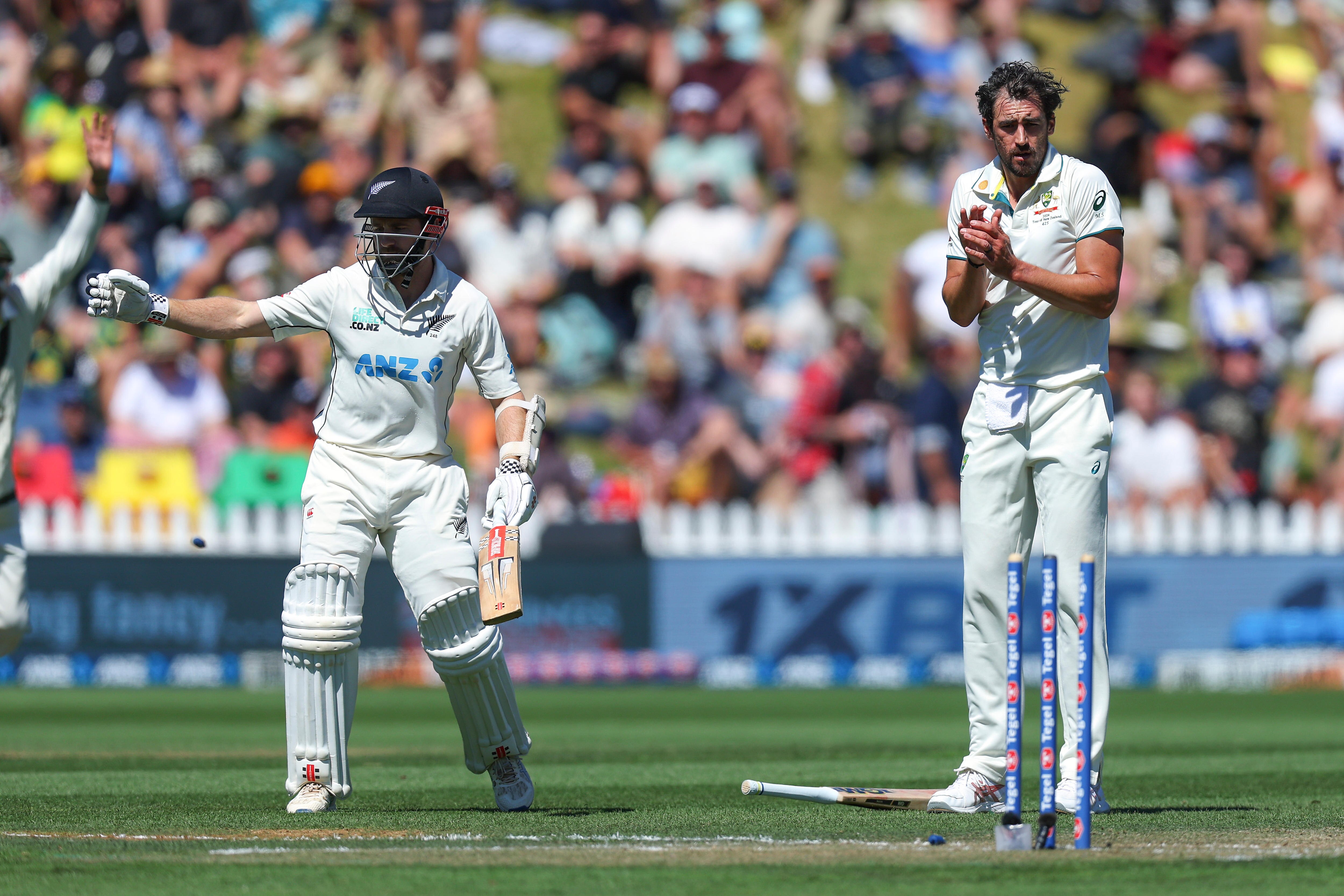 Mitchell Starc flinches as the stumps are thrown down, with Kane Williamson out of his crease behind him