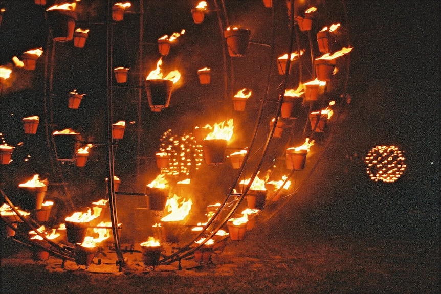 A circular structure filled with pots of fire