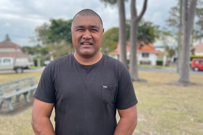 Tautai Kefu stands in a park.