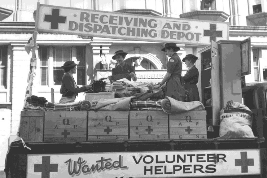 Female Red Cross volunteers recruit helpers on a float in 1939.