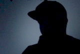 Silhouetted man in hat