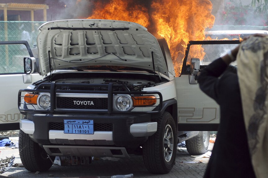 A car burns during protests at the US embassy in Sana'a, Yemen.