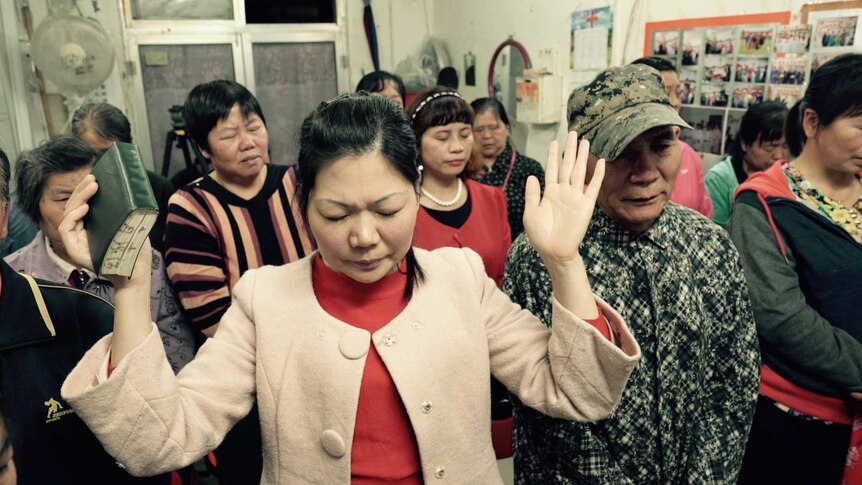 People pray at a small Protestant underground that operates in a shop front in Beijing, China.