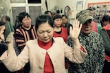 People pray at a small Protestant underground that operates in a shop front in Beijing, China.