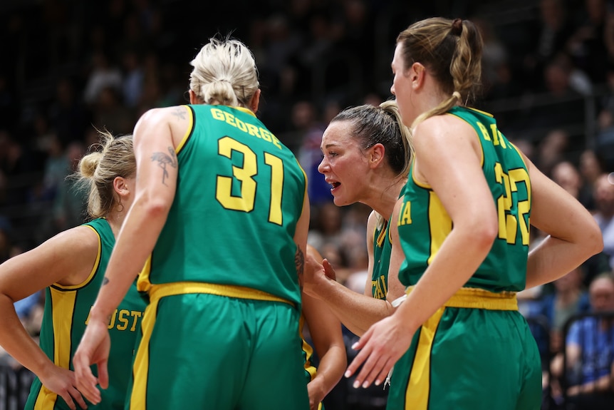 Tess Madgen leans forward and shouts in a huddle of four women