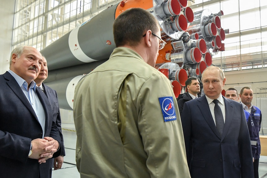 Vladimir Putin and Alexander Lukashenko in a media event in a viewing room with rockets.
