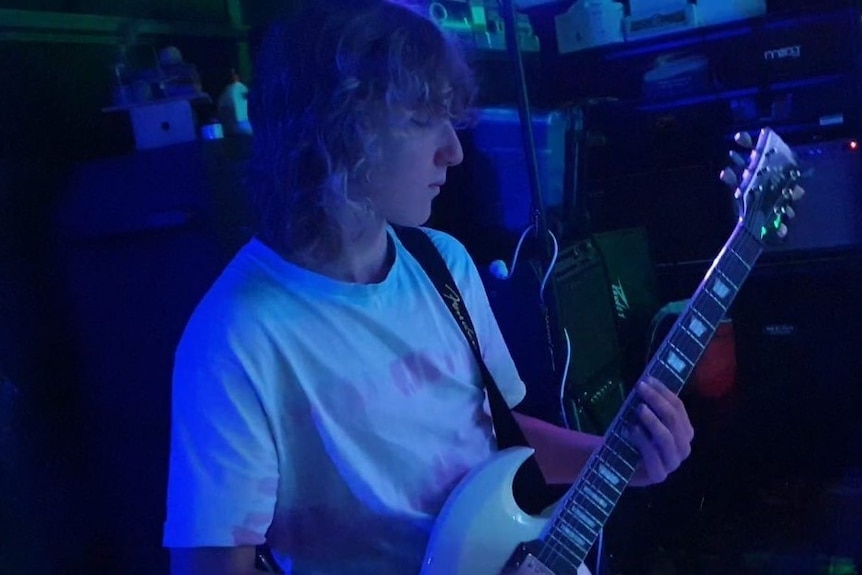 Teenage boy playing guitar. 