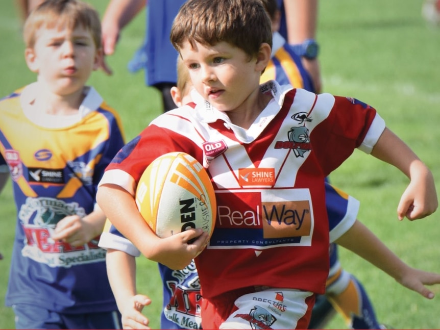 A young player runs with the football