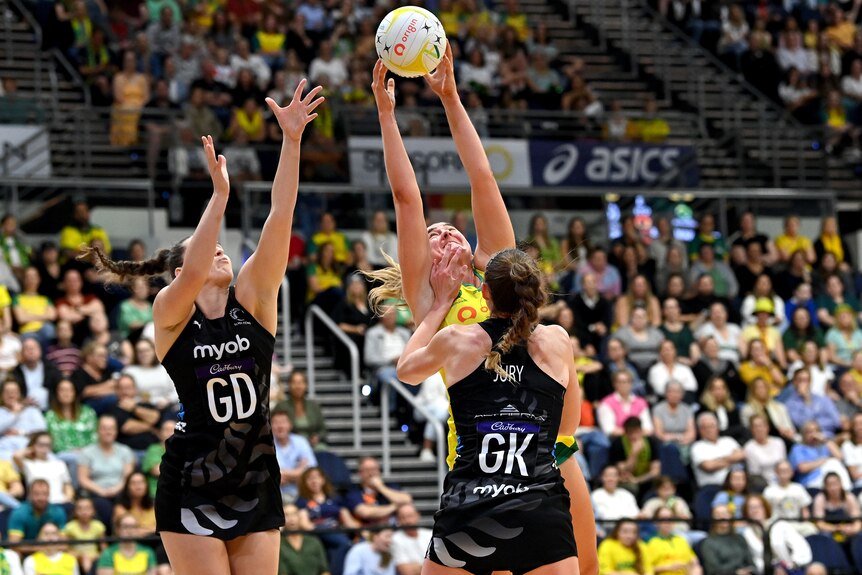 Sophie Garbin looks skyward and jumps for the ball as she is sandwiched by two Silver Ferns defenders