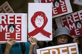 Protesters hold up placards to demand the release of Singaporean teenager Amos Yee outside the Singapore Consulate in Hong Kong, China July 5, 2015.