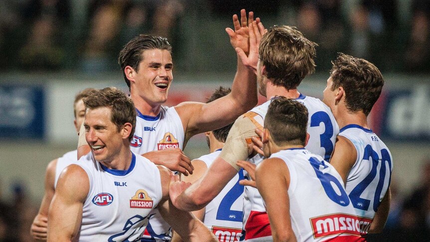 Western Bulldogs players celebrate a goal against the Eagles