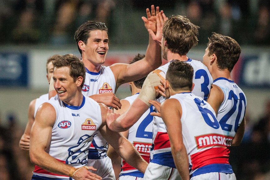 Western Bulldogs players celebrate a goal against the Eagles