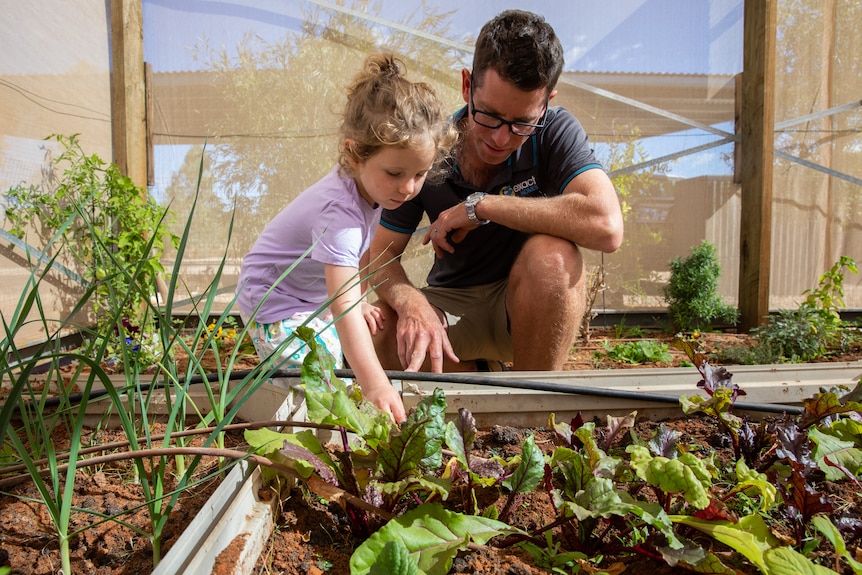 Hayley and Jack tend to the vegetable garden together in the backyard. 